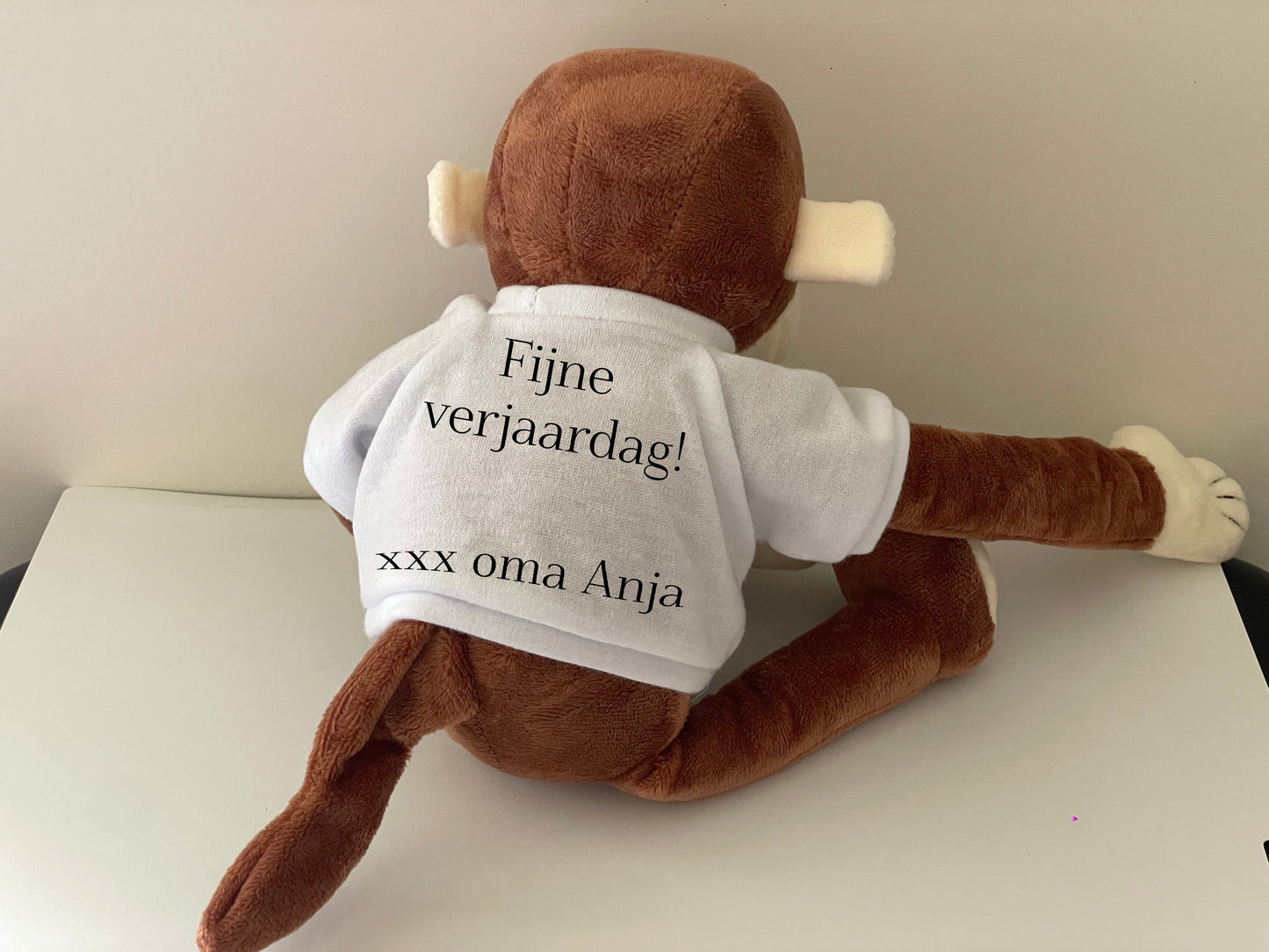 Achterzijde van het shirtje van de aap is bedrukt met tekst
