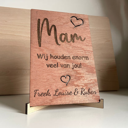 Houten bordje met opschrift: 'Mam wij houden enorm veel van jou'  met de namen van de kinderen eronder gegraveerd