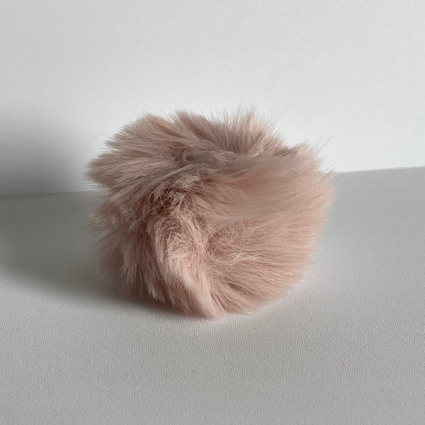 Zalmkleurige pompom voor aan je sleutelhanger