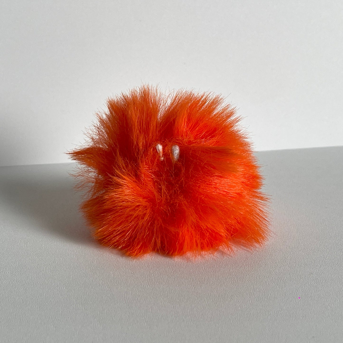 Oranje pompom voor aan je sleutelhanger