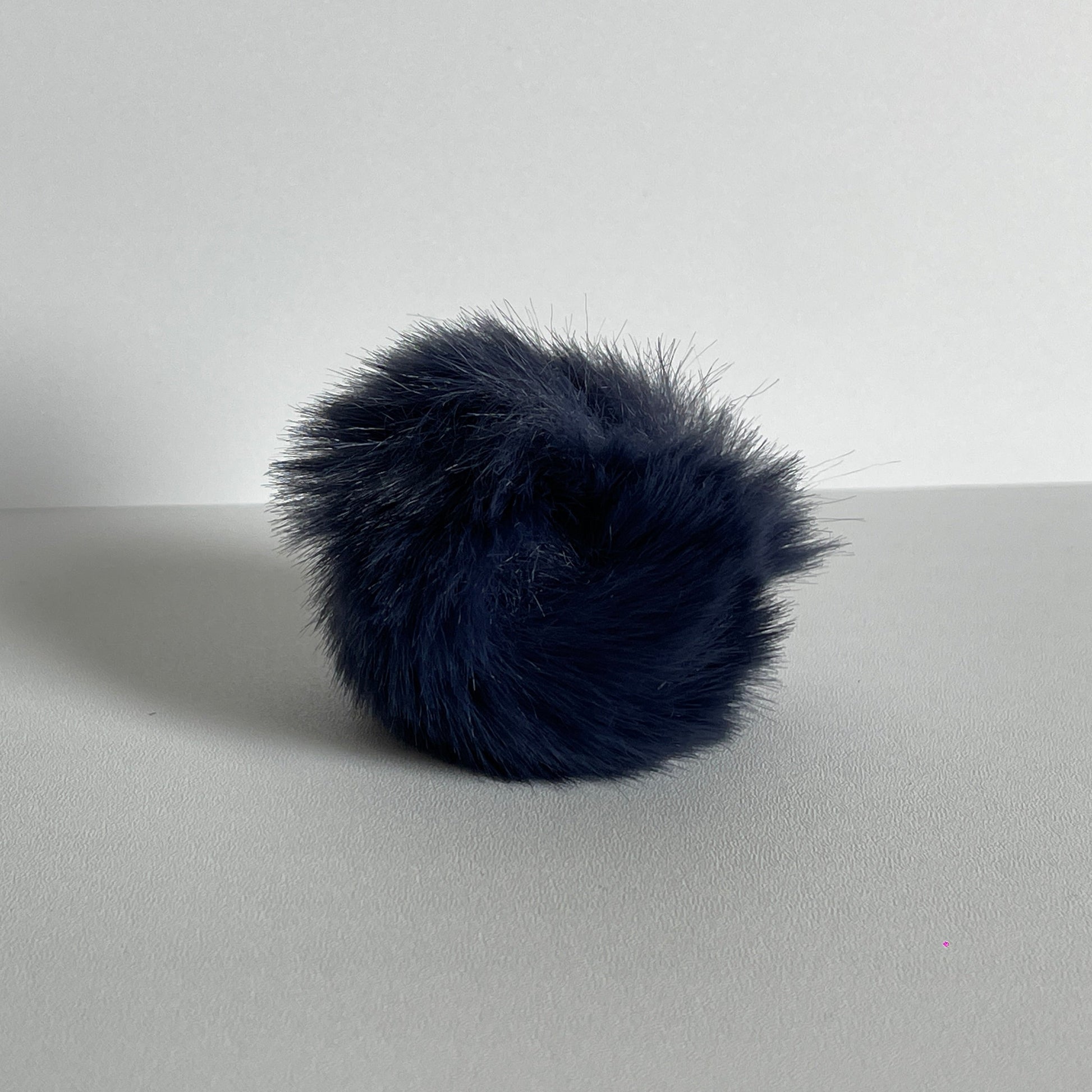 Zwartblauwe pompom voor aan je sleutelhanger